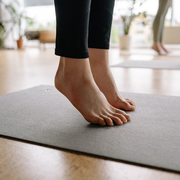 Person stretching gently on a yoga mat with soft light.